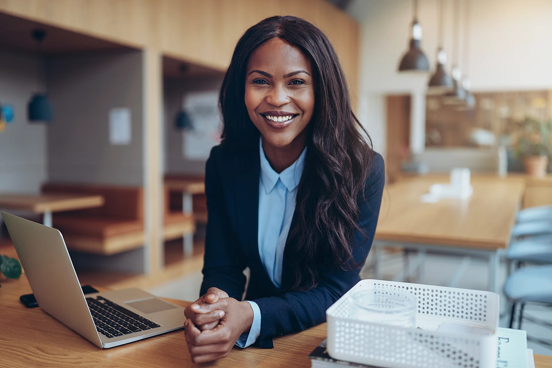 Woman smiling sitting at her desk with laptop